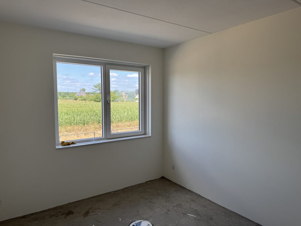 Lege kamer met gladde, lichte wanden en een raam