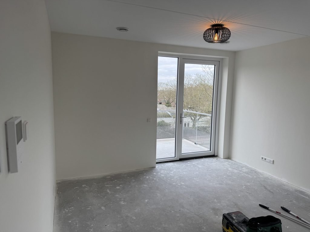 Lege kamer met kale wanden en openslaande deuren